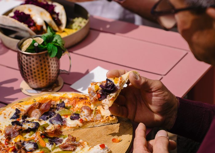 Guests sharing pizza and drinks