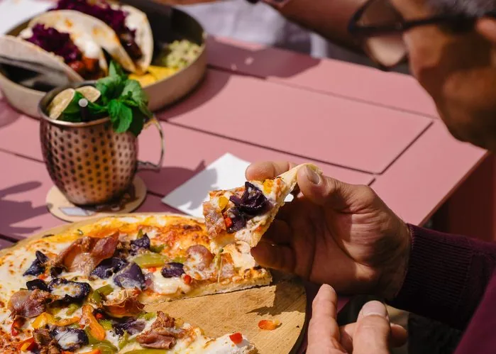 Guests sharing pizza and drinks