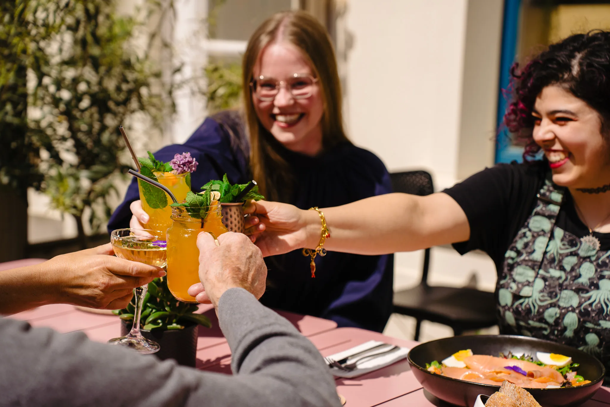Friends raising colourful drinks at Dalu